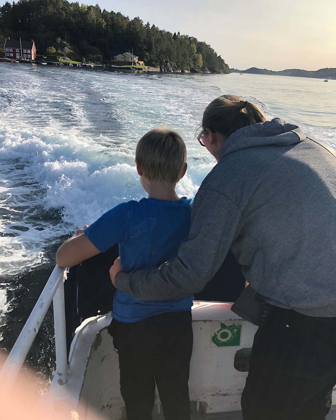 To personer står tett sammen med ryggen til, vendt mot det samme.